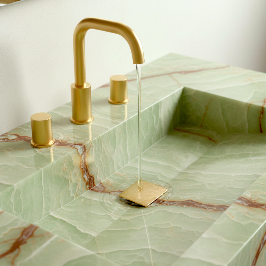 Gold faucet on a green onyx sink