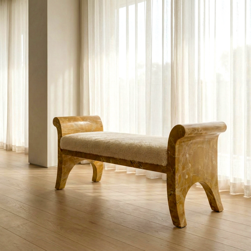 Marble bench with beige cushion in a room with large windows and light curtains.